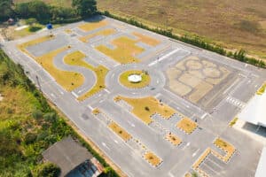 Vue aérienne de dessus d'un centre de test de conduite automobile avec rue. Terrain de cours, école de véhicules d'entraînement.