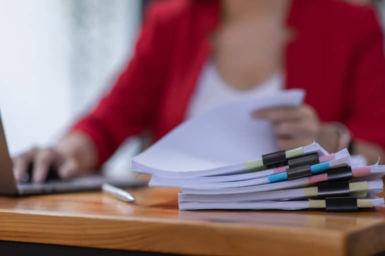 Femme qui épluche plusieurs document d'une entreprise RGE