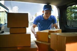 homme portant une tenue bleu et une casquette bleue portant des carton Service de livraison, livraison à domicile et concept d'expédition franchise