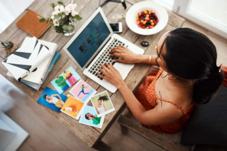 femme portant une robe orange tapant sur son ordinateur et visitant les articles de blog (maillage interne)