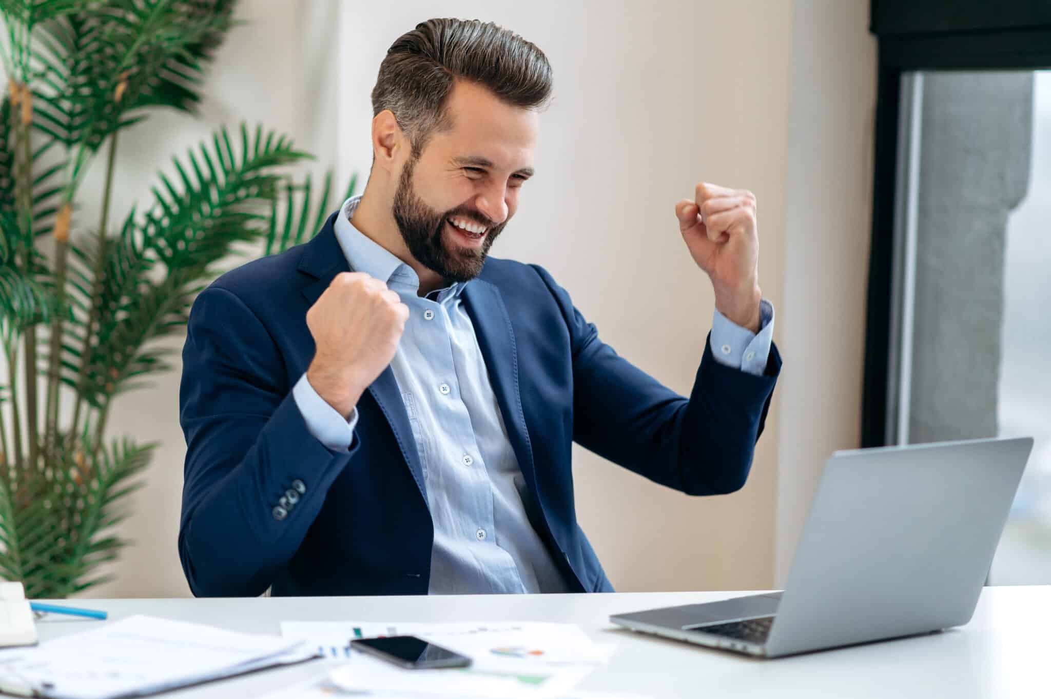 Homme d'affaires caucasien heureux et chanceux en costume, PDG d'une entreprise, directeur, est assis à son bureau dans une entreprise RGE