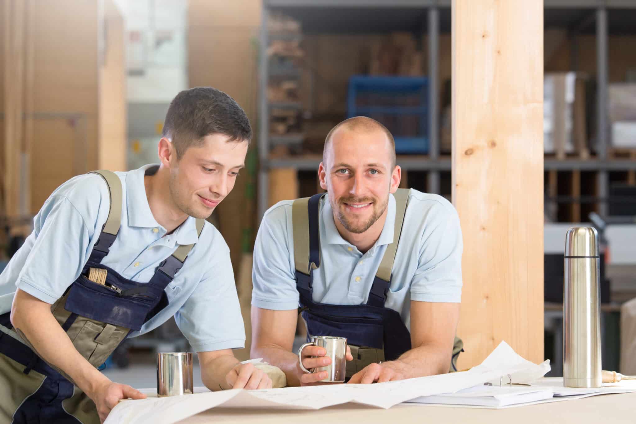 Deux artisans avec des tasses en métal qui parlent